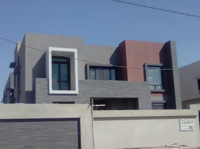 CemTrox coating over a modern house. Straigh lines architecture, with medium and dark grey colors, and two highligths in white aad rust  colors. 